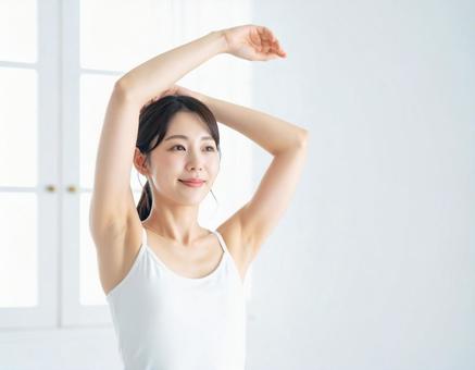 腕を上げる 若い女性の写真