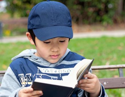 公園で本を読む少年 公園で本を読む少年の写真