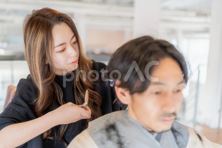 後ろ髪をカットバサミで整える美容師の女性 ビジネス,ビジネスウーマン,キャリアウーマンの写真素材