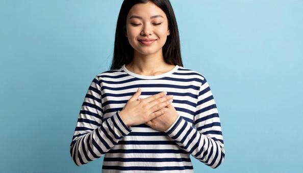 胸に両手をあてる女性 胸に両手をあてる女性の写真