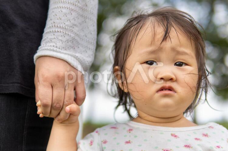 母親と手を繋いで歩く子供が不安そう 手,繋ぐ,不安の写真素材