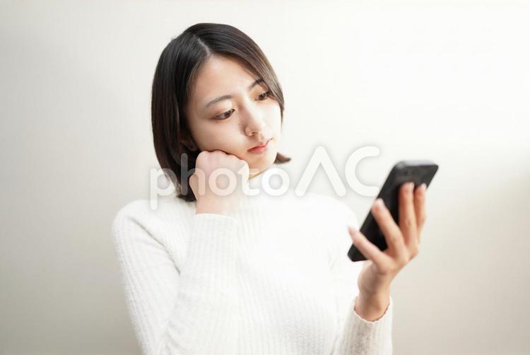 スマホを操作する女性 20代,屋内,女性の写真素材