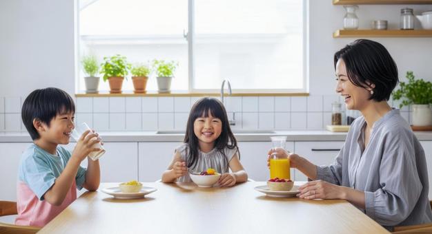 母と子供2人が食卓にいる朝食シーン 母と子供2人が食卓にいる朝食シーンの写真