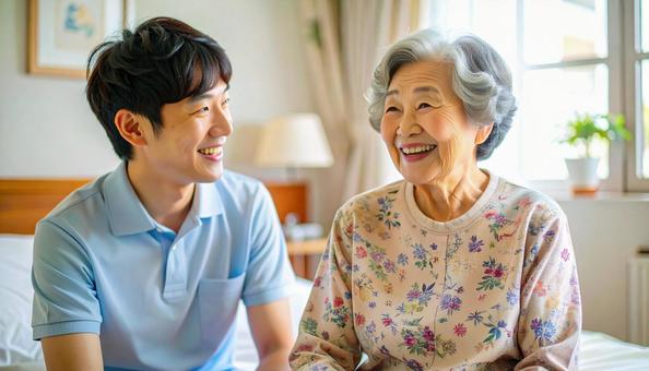 笑顔で話をする男性介護士と高齢女性の写真