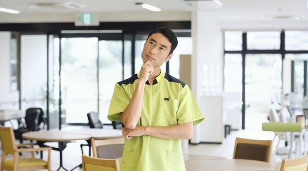介護施設で悩むアジア人介護福祉士 介護施設で悩むアジア人介護福祉士 介護福祉士,介護士,悩むの写真素材