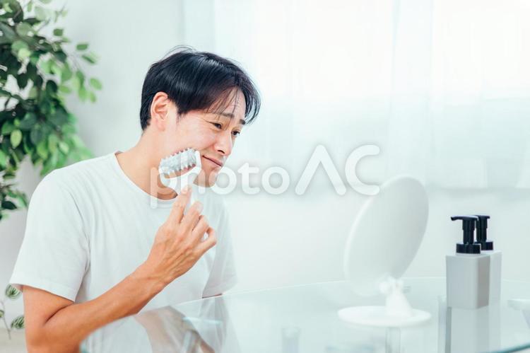 美顔ローラーを使う男性（困る） 美顔ローラー,顔痩せ,むくみの写真素材