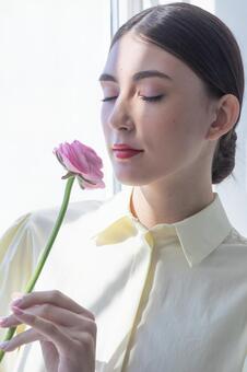 穏やかな表情で目を閉じる外国人女性 女性,花,ラナンキュラスの写真素材
