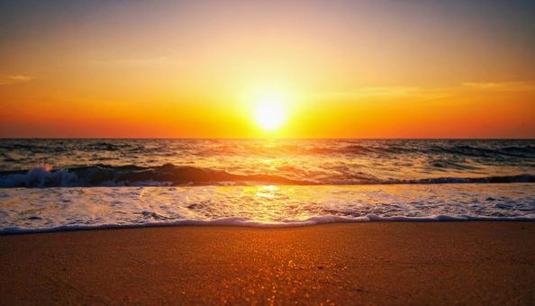 夕暮れ時の日が沈む太陽と海 夕暮れ時の日が沈む太陽と海の写真