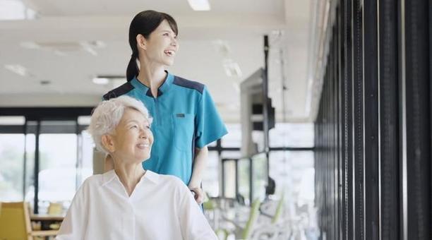 車椅子で散歩をする高齢者と介護士 車椅子で散歩をする高齢者と介護士 高齢者,車椅子,介護士の写真素材