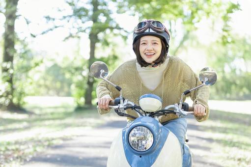 バイクに乗る若い女性 バイクに乗る若い女性 バイク,女性,スクーターの写真素材