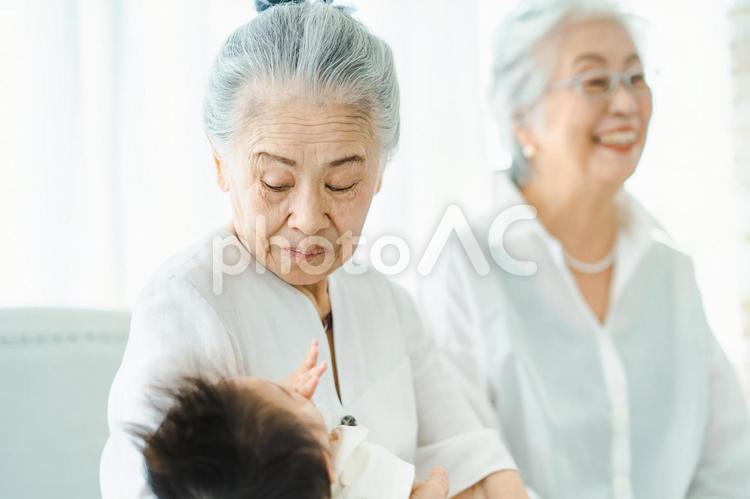 赤ちゃんを抱っこするシニア女性 孫,おばあちゃん,肌の写真素材