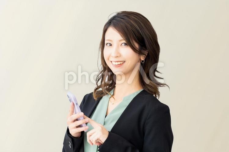 スマホを持つ笑顔の女性・ビジネスウーマン 女性,ビジネス,ビジネスウーマンの写真素材
