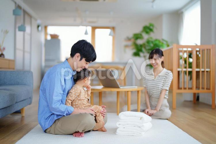母の方を見る父の膝に座っている子供 親子,笑顔,嬉しいの写真素材