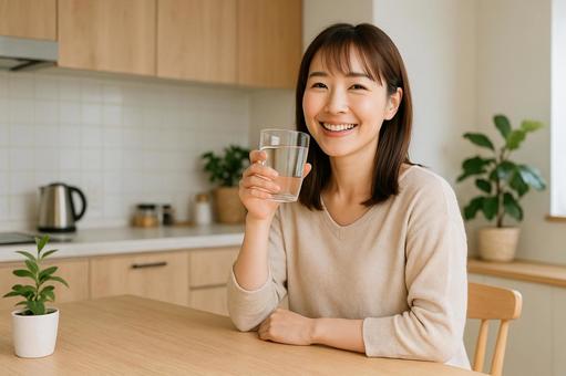 キッチンで水を飲む女性 キッチンで水を飲む女性の写真