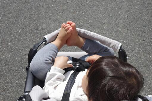 ベビーカーのガードに足を乗せる子ども ベビーカー,子ども,安全ベルトの写真素材