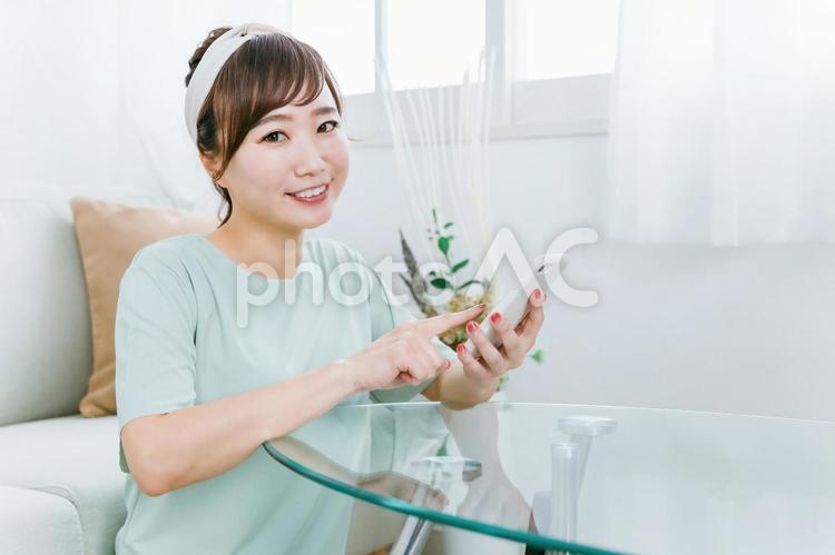 スマホを使う笑顔の日本人女性（アプリ） スマホ,女性,スマートフォンの写真素材