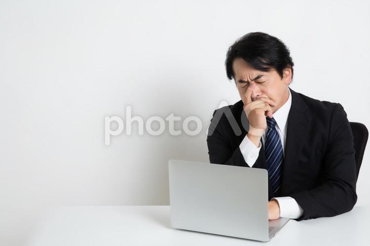悩みながら仕事をしている中年のサラリーマン男性（コピースペース） 中年,上司,会社員の写真素材