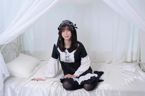 ベッドに腰掛けるメガネの地雷系女子 ベッドに腰掛けるメガネの地雷系女子 カメラ目線,眼鏡,メガネの写真素材