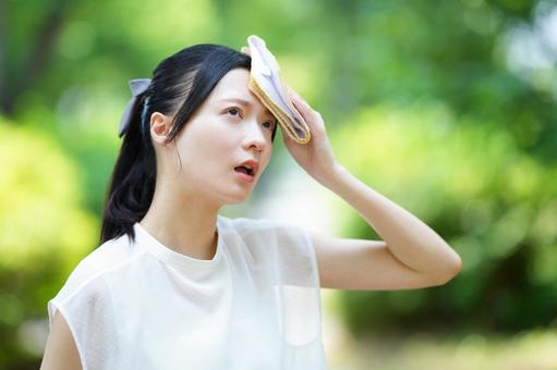 女性がハンカチを額に添える 女性,暑い,ハンカチの写真素材