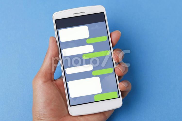 スマホを持つ人 ビジネス,line,トークの写真素材