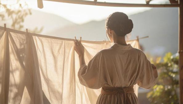 洗濯物を干す女性 洗濯物を干す女性の写真