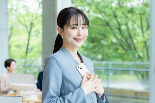 スマホを操作するビジネスウーマン スマホ,笑顔,ビジネスウーマンの写真素材