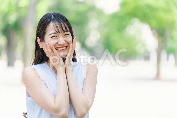 新緑の中で笑顔の日本人女性（小顔） 笑顔,女性,嬉しいの写真素材
