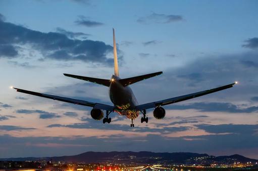 夕暮れに着陸する旅客機 夕暮れに着陸する旅客機 飛行機,空港,着陸の写真素材